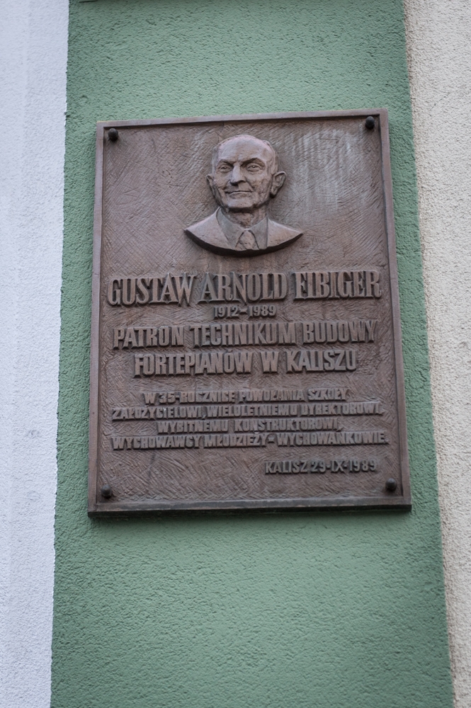Tablica Gustawa Arnolda (III) Fibigera na budynku Technikum Budowy Fortepianów w Kaliszu